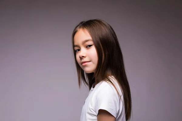 Portréja egy bájos barna kis lány, barna háttér elszigetelt. — Stock Fotó