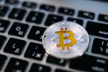 Cryptocurrency fiziksel gümüş bitcoin madeni para ile sarı b oturum üstünde belgili tanımlık klavye. Cryptocurrency kavramı.