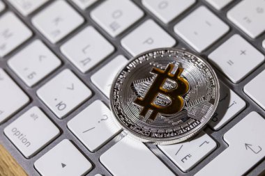 Cryptocurrency fiziksel gümüş bitcoin madeni para ile sarı b oturum beyaz klavyede