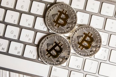 Beyaz klavye üzerinde gümüş bitcoin paralar. Yakın çekim. Bitcoin kadar. Cryptocurrency
