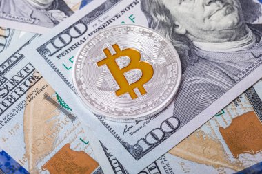 Gümüş bitcoin 100 dolar faturaları üzerinde yatıyor. Bitcoin dolar arka plan üzerinde