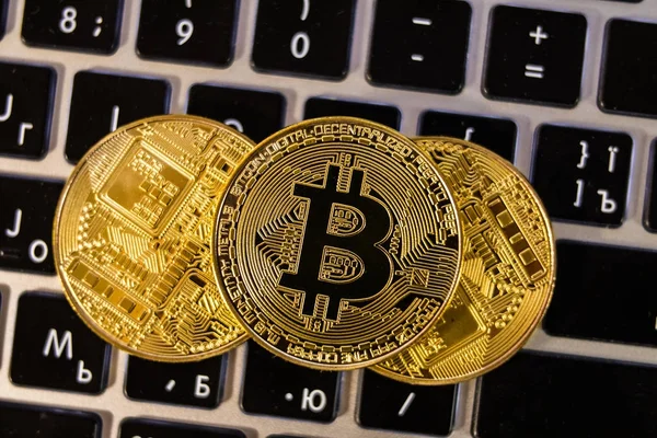 Vista superior pila de tres Bitcoins de oro criptomoneda en el teclado de la computadora. Concepto criptomoneda — Foto de Stock