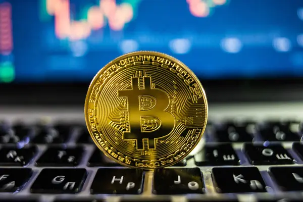 Moneda de Bitcoin de oro con concepto blockchain en el teclado portátil con monedas y gráficos y gráficos. Crypto seguridad de inversión y estrategia . — Foto de Stock