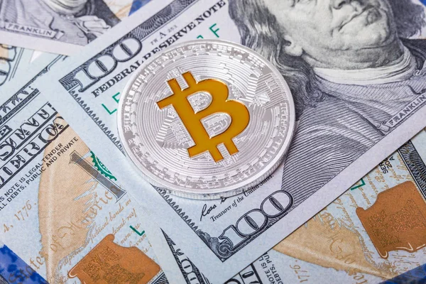 Ασημένια bitcoin βρίσκεται στα 100 δολάρια λογαριασμούς. Το Bitcoin σε φόντο δολάρια — Φωτογραφία Αρχείου