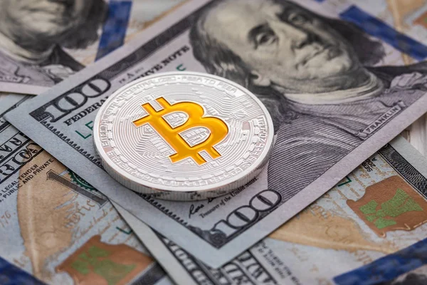 Ασημένια bitcoin βρίσκεται στα 100 δολάρια λογαριασμούς. Το Bitcoin σε φόντο δολάρια. Εξόρυξη έννοια — Φωτογραφία Αρχείου
