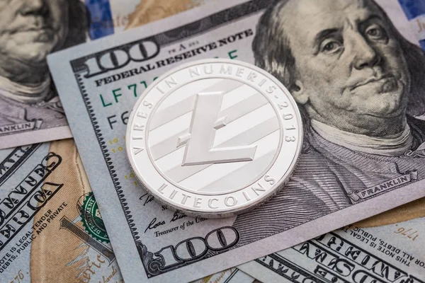 Ασημένιο νόμισμα Litecoin σε φόντο τραπεζογραμματίων δολαρίων. Έννοια των επιχειρήσεων και της τεχνολογίας. Ψηφιακό νόμισμα φυσικό μεταλλικό litecoin κέρμα - εικονικό χρήμα έννοια. — Φωτογραφία Αρχείου