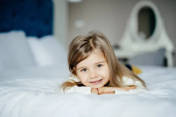 Menina bonito em pijama com sorriso na cama pela manhã — Fotografia de Stock