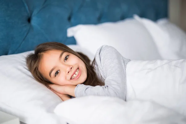 Очаровательная маленькая девочка проснулась в своей постели дома — стоковое фото