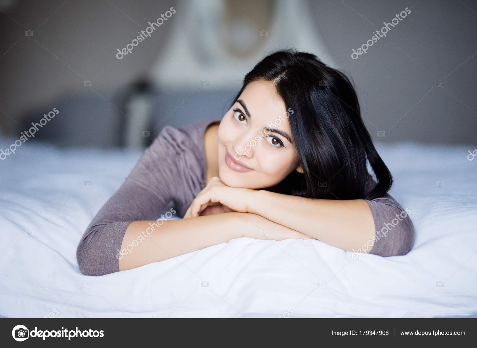Femme Au Lit Couché Sur Le Ventre Souriant Heureux Et - 