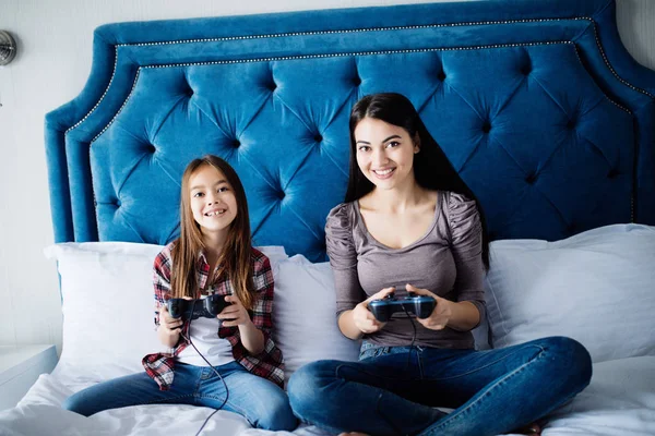 Gelukkige familie samen. moeder en haar kind meisje spelen van videospellen. — Stockfoto