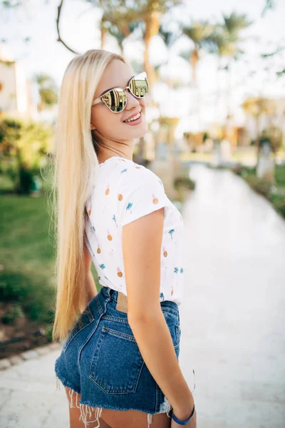 Sonriente linda mujer joven en sombrero caminando en el resort de verano — Foto de Stock