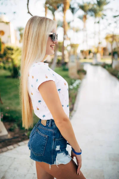 Yaz aylarında güneş gözlüğü neşeli genç kadın arka planlar palms — Stok fotoğraf