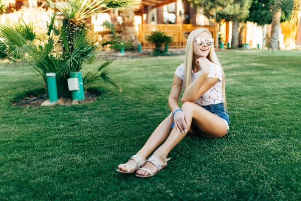 뷰티 금발 여자 여름 일에 선글라스에 잔디에 앉아. 여름. — 스톡 사진