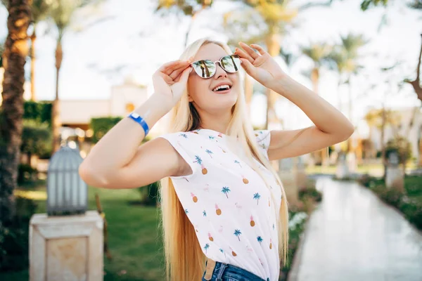 夏にサングラスで陽気な若い女性の背景のヤシの木します。 — ストック写真