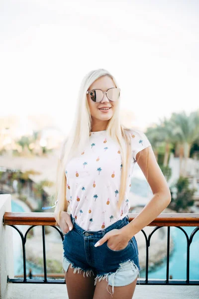 Mulher loira feliz na varanda do quarto de hotel no céu e palmas de fundo . — Fotografia de Stock