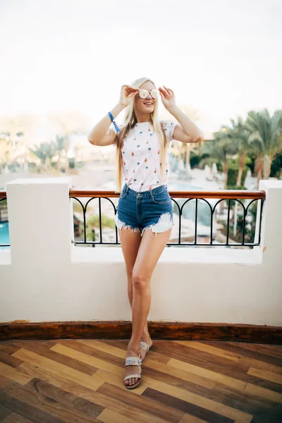 Mulher loira feliz na varanda do quarto de hotel no céu e palmas de fundo . — Fotografia de Stock