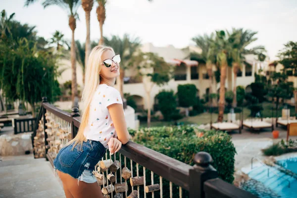 Cherful jonge sexy vrouw in resort, vakantie, staande, poseren naast het zwembad. — Stockfoto
