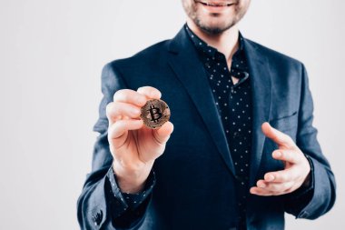 Yakışıklı delikanlı mevcut altın bitcoin gri arka plan üzerinde izole el yakın çekim