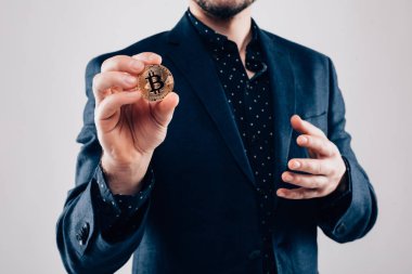 Bitcoin gri arka plan üzerinde izole adam elinde, yakın çekim