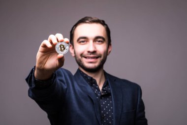 Handome iş adamı bitcoin koyu arka plan üzerinde izole kamera işaret etti