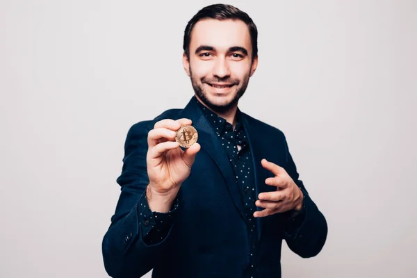 Jovem bonito homem presente ouro bitcoin isolado no fundo cinza — Fotografia de Stock