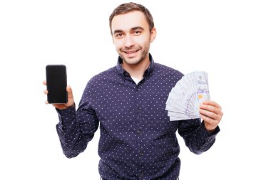 Süre boş ekran cep telefonu gösterilen ve beyaz arka plan üzerinde izole kamera bakarak para banknot demet tutan gülümseyen bir neşeli adam portresi