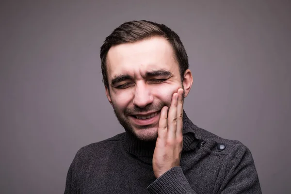 Homme malade déprimé ayant mal aux dents et touchant la joue isolé sur fond sombre — Photo