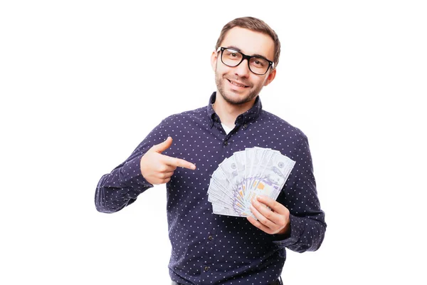 Retrato de un hombre sonriente y exitoso con traje y gafas apuntando con el dedo a un montón de billetes de dinero aislados sobre blanco —  Fotos de Stock