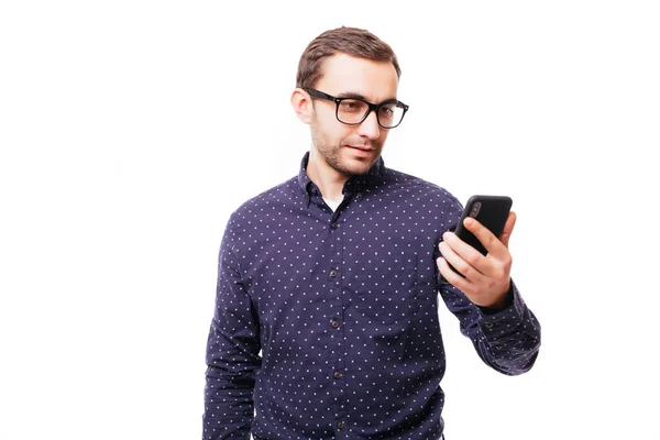 A escrever mensagem de texto. Sorrindo homem com barba em pé sobre fundo isolado branco e segurando telefone celular no branco — Fotografia de Stock