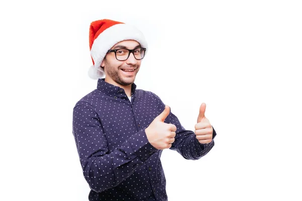 Stilig affärsman bära santa hatt visar tummen på vit isolerade bakgrund. — Stockfoto