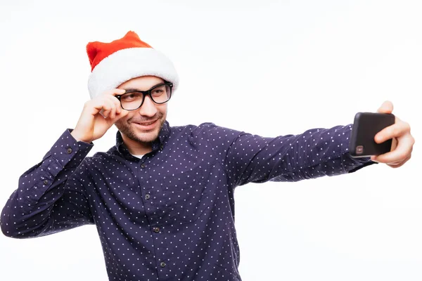 Gelukkig emotionele jongeman dragen van Kerstmis KERSTMUTS boven witte muur geïsoleerd staan. — Stockfoto