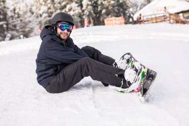 snowboard yüksek dağlarda yamaç kenarında oturur ve sürüş önce fotoğraf makinesi bakar