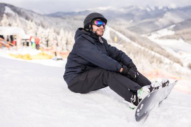 Yolculuk önce bir kayak merkezinde oturan snowboarder