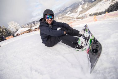 Yolculuk önce bir kayak merkezinde oturan snowboarder