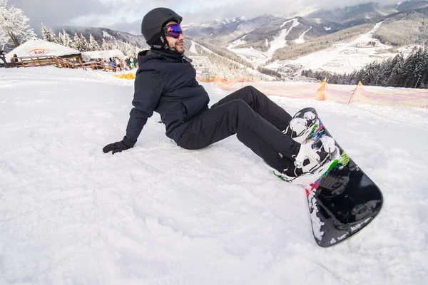 Snowboarder nos botões da colina fixação antes do passeio na colina de neve — Fotografia de Stock