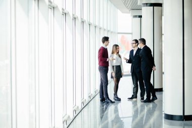 İş adamları office hall içinde pencere arka plan üzerinde yürümek.
