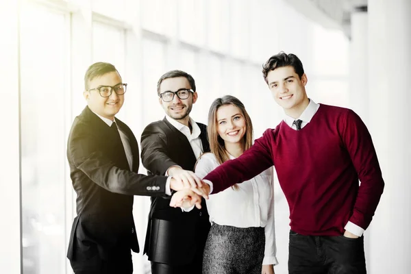 International business team showing unity with their hands together in office — Stock Photo, Image