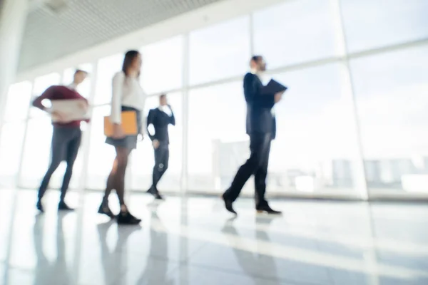 Toute la longueur du groupe de jeunes gens d'affaires heureux marchant dans le couloir dans le bureau ensemble. Équipe de marche . — Photo