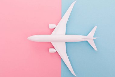 Minyatür oyuncak uçak mavi ve gül arka plan üzerinde. Uçak gezisi. Üstten Görünüm