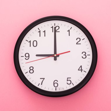 Gül arka plan üzerinde izole büyük duvar saati. Saat 9'da.