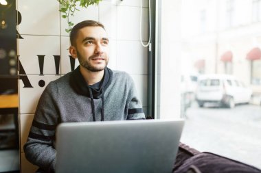 Yakışıklı erkek girişimci tipik Yöneticisi, kafede otururken işbirliği görüşmek üzere toplantı düzenleme dizüstü bilgisayarın klavyesinde pazarlama corporation Web sitesinin içerik için haber