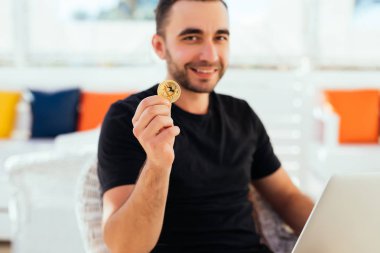 Dizüstü bilgisayar ile yakışıklı delikanlı bitcoin güverte üzerinde yaz meslek beack kafede oturan fotoğraf makinesinde işaret etti. Yaz meslek bitcoin değerini kontrol.