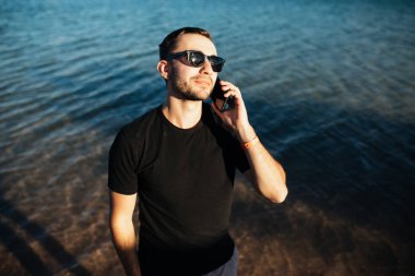 Selfie tatil sırasında cep telefonuyla deniz plajda alarak mutlu genç adam