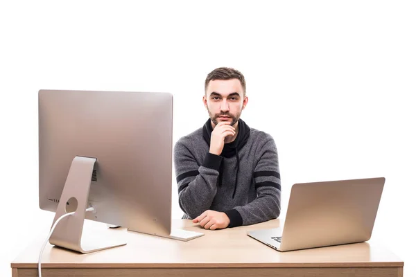 Fiducioso uomo d'affari seduto a tavola con laptop e personal computer e guardando la fotocamera isolata su sfondo bianco — Foto Stock