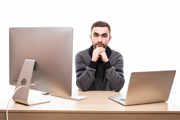 Fiducioso uomo d'affari seduto a tavola con laptop e personal computer e guardando la fotocamera isolata su sfondo bianco — Foto Stock