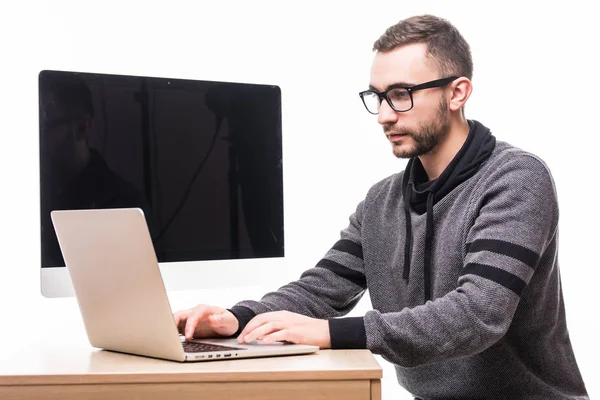 Bonito homem de óculos trabalhando no laptop com tela de monitor em suas costas — Fotografia de Stock