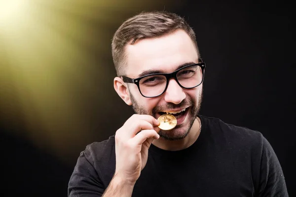 Altın bitcoin siyah arka plan üzerinde izole ısırma gözlüklü bir adam portresi kapatın. Tonned resim. — Stok fotoğraf