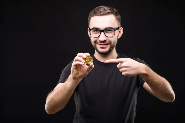 Szemüveget hord, rámutatott a bitcoin elszigetelt fekete háttér fekete inget fiatalember portréja — Stock Fotó