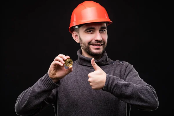 Гарний юнак шахтаря в захисну hemlet вказав bitcoin з великими пальцями вгору ізольовані на чорному фоні — стокове фото