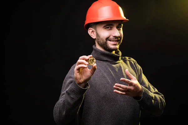 Красенем шахтаря в захисну hemlet присутній bitcoin ізольовані на чорному тлі — стокове фото